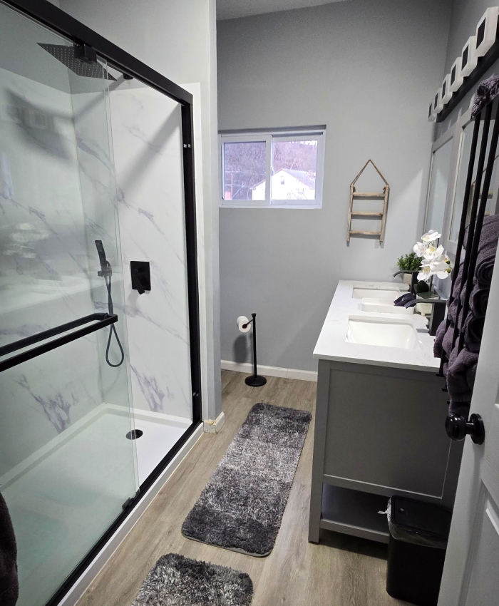 Salle de bain moderne avec douche vitrée, double vasque et finitions soignées